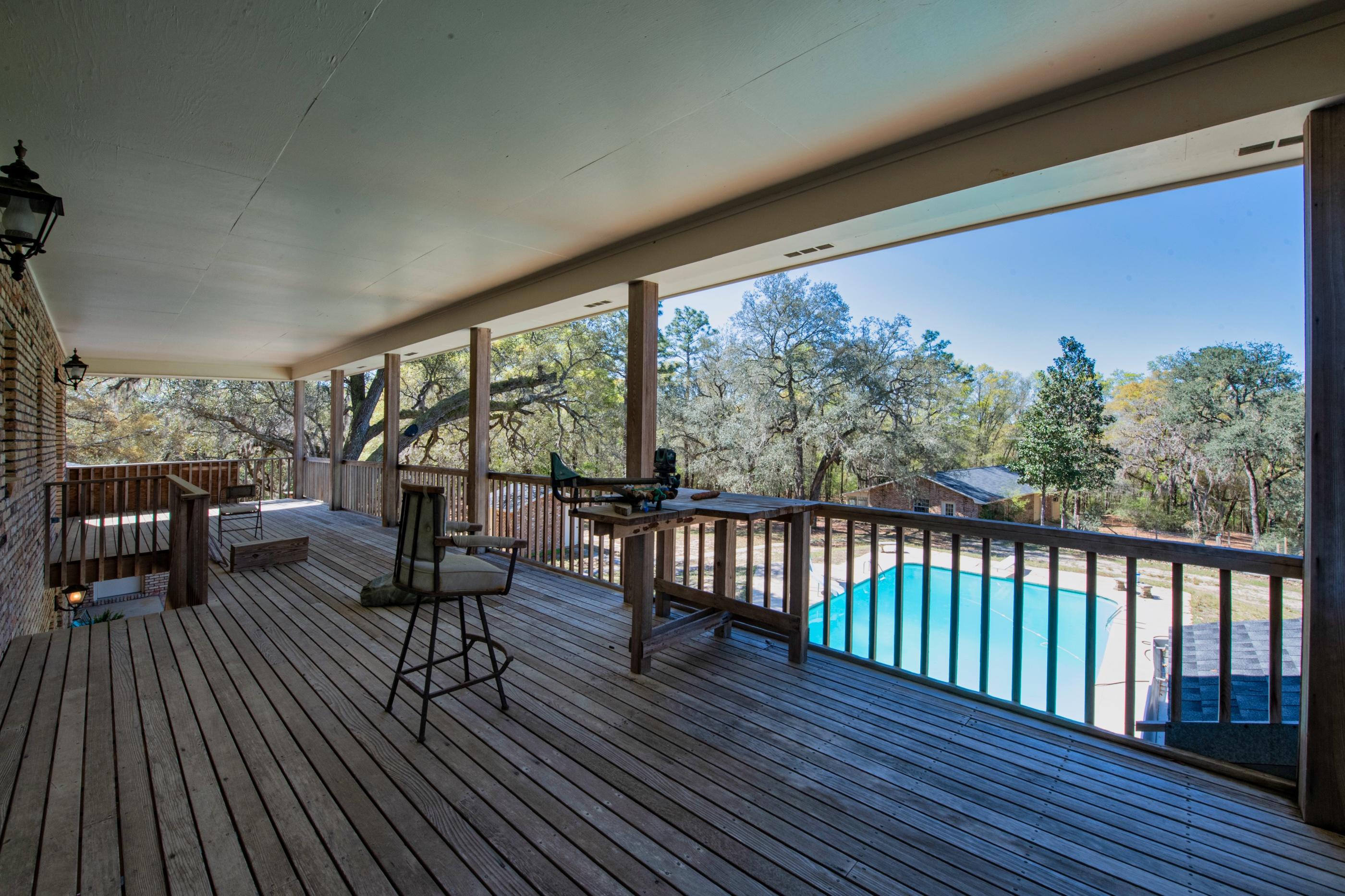1 Lindley Road Crestview, FL 32536 - Photo 47 of 80 a balcony with wooden floor outdoor seating and yard in the back