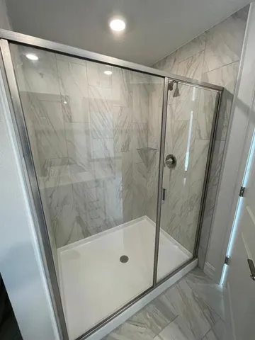 a bathroom with a shower and a glass door