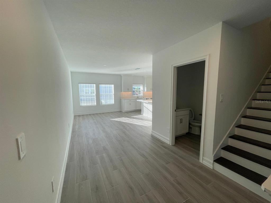 3477 Wildflower Vly Lane Wesley Chapel, FL 33543 - Photo 15 of 38 a view of a room with wooden floor and stairs