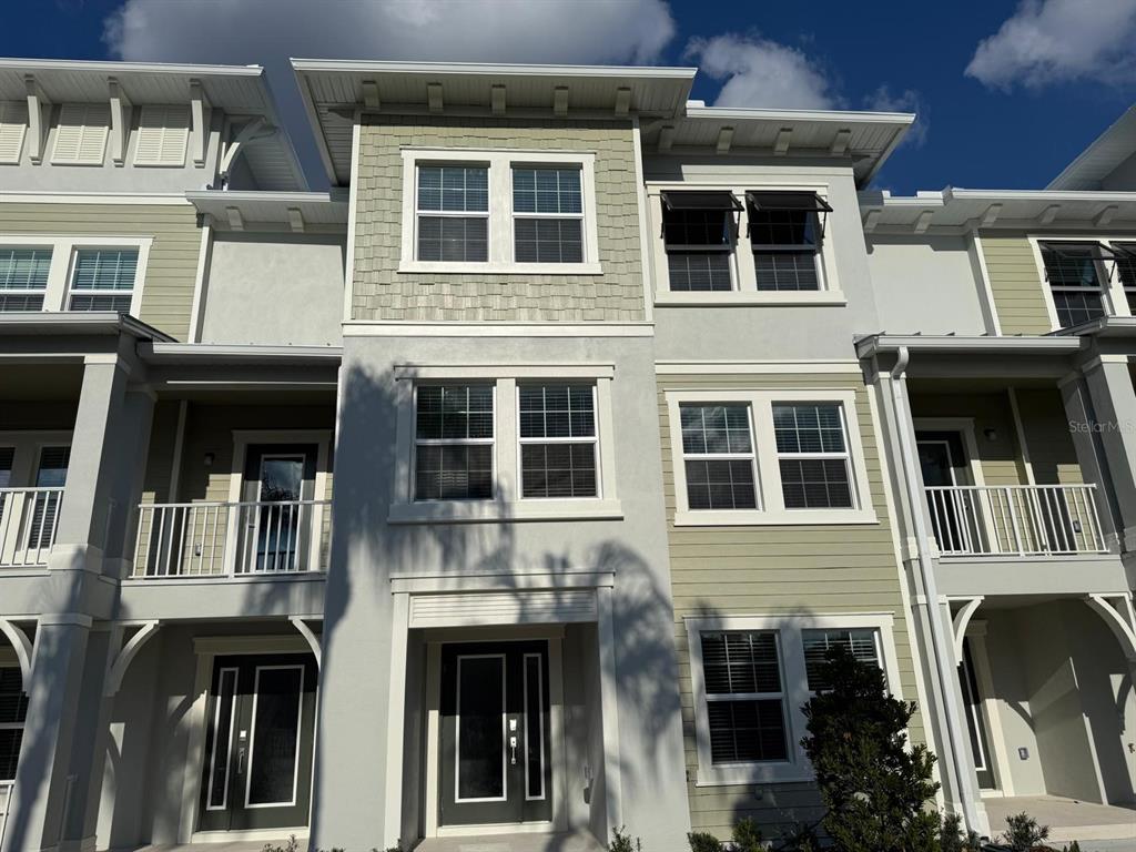 3477 Wildflower Vly Lane Wesley Chapel, FL 33543 - Photo 2 of 38 a front view of a residential apartment building with a yard