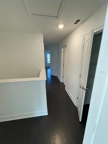 a view of an empty room with wooden floor