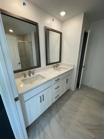 a spacious bathroom with double vanity and a mirror