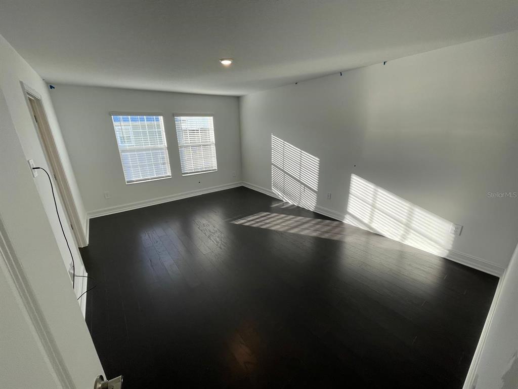 3477 Wildflower Vly Lane Wesley Chapel, FL 33543 - Photo 24 of 38 an empty room with wooden floor and windows