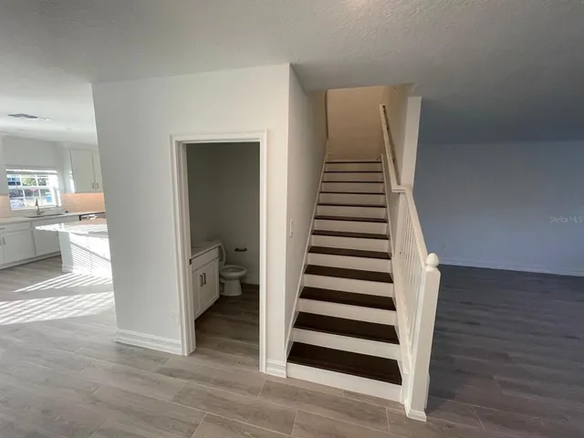 a view of a hallway with wooden floor and entryway