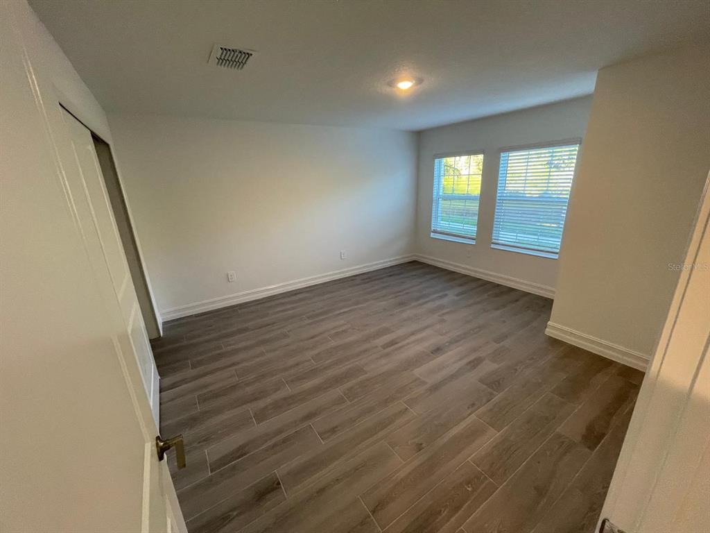 3477 Wildflower Vly Lane Wesley Chapel, FL 33543 - Photo 37 of 38 wooden floor in an empty room with a window