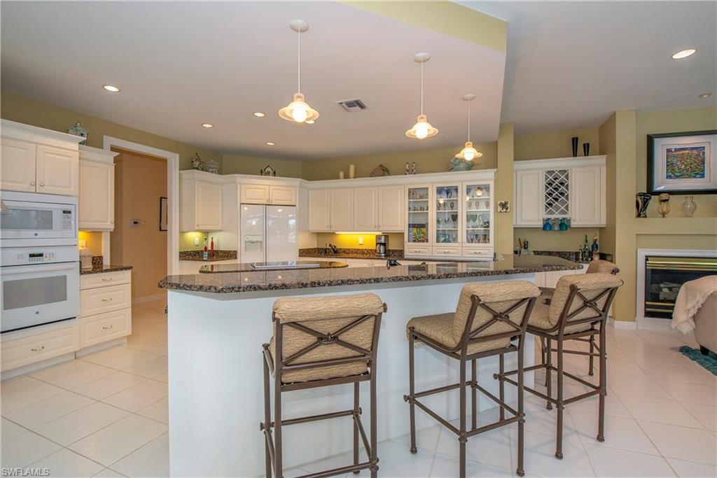 20128 Cheetah Lane Estero, FL 33928 - Photo 16 of 30 a kitchen with stainless steel appliances kitchen island granite countertop a sink and cabinets