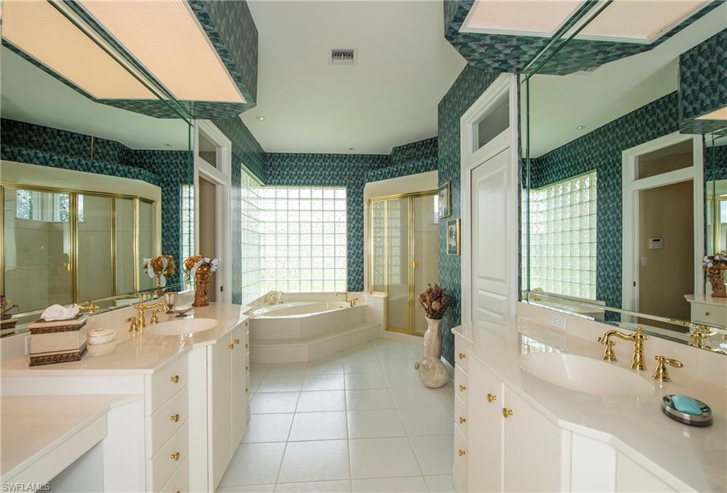 20128 Cheetah Lane Estero, FL 33928 - Photo 10 of 30 a bathroom with a double vanity sink a mirror and a bathtub