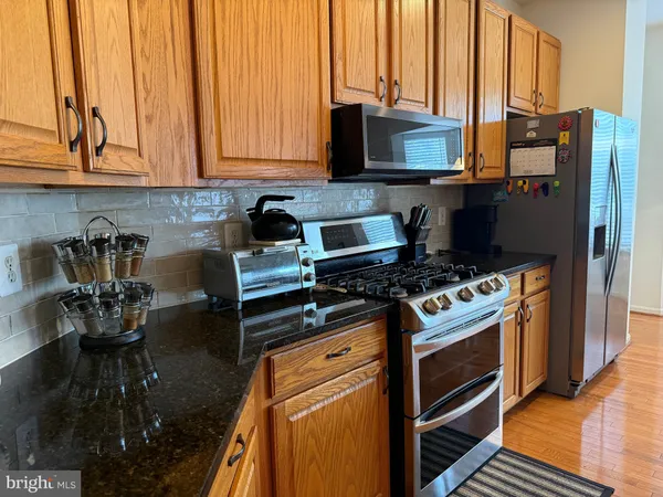 a kitchen with stainless steel appliances granite countertop a stove and a refrigerator