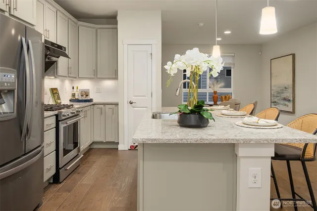 a kitchen with kitchen island granite countertop a sink cabinets and stainless steel appliances