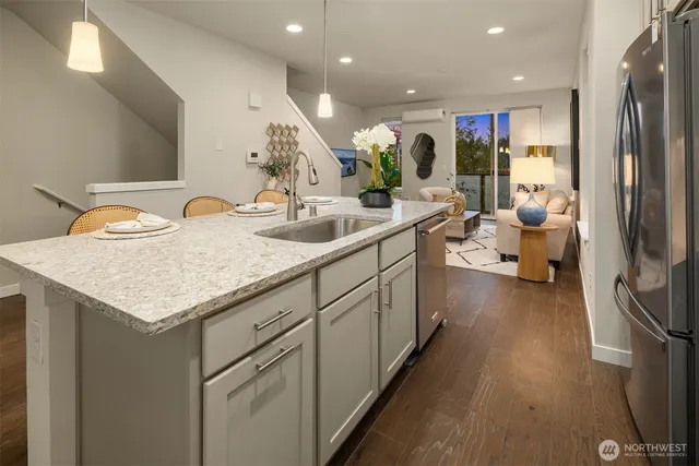 a kitchen with a sink dishwasher and a refrigerator with wooden floor