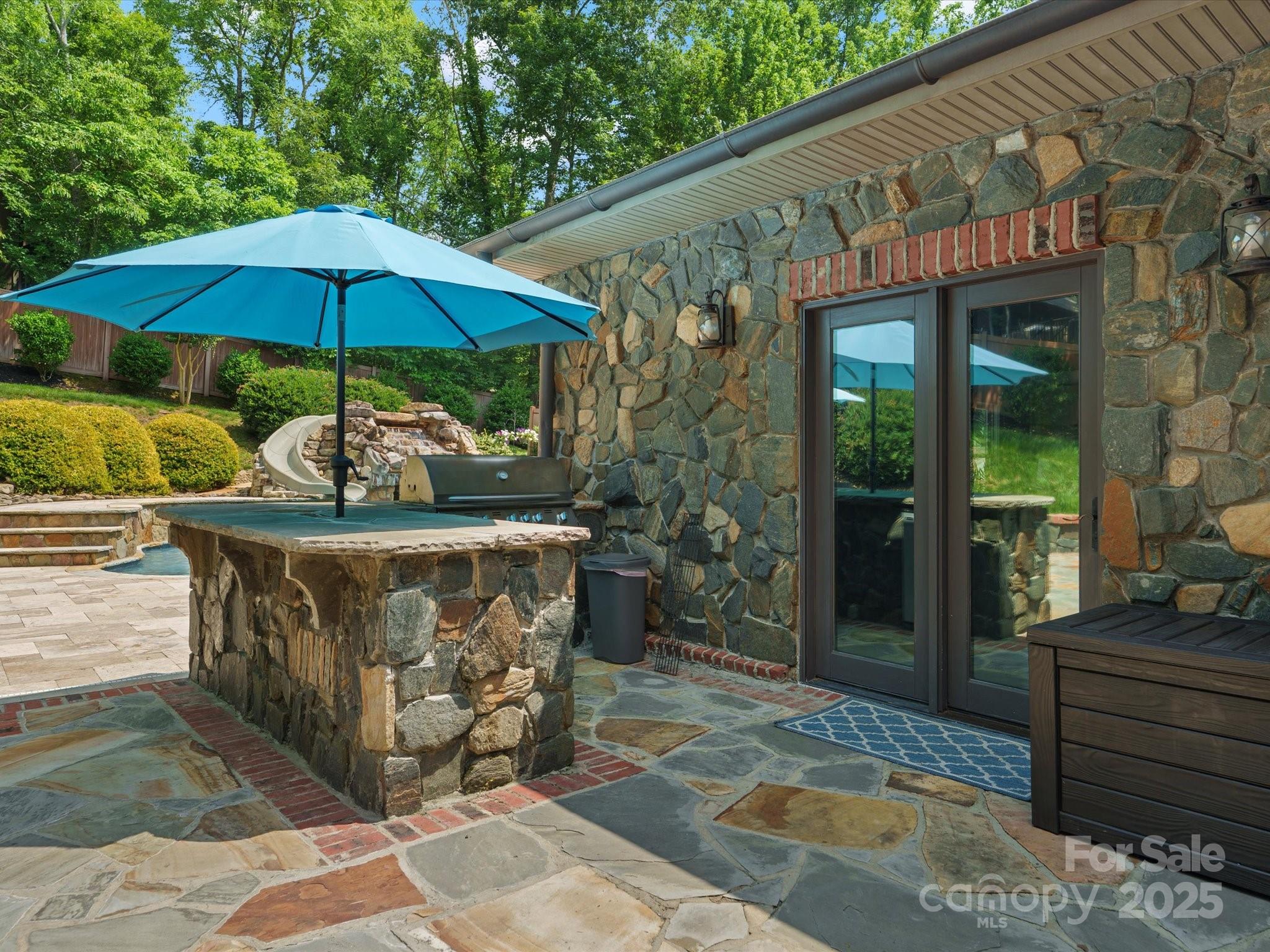 315 Mountainview Drive Charlotte, NC 28270 - Photo 23 of 34 a view of a patio with table and chairs under an umbrella