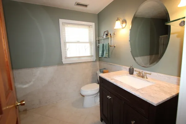 a bathroom with a sink a toilet and a window