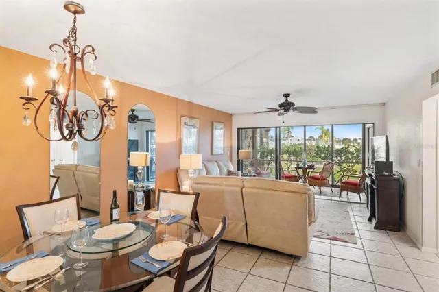 a living room with furniture a floor to ceiling windows and a chandelier