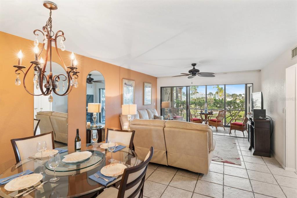 2275 South McCall Road, Unit 102 Englewood, FL 34224 - Photo 13 of 48 a living room with furniture a floor to ceiling windows and a chandelier