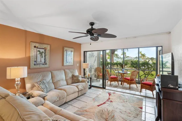 a living room with furniture ceiling fan and a large window