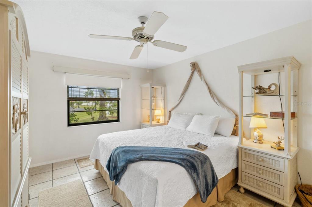 2275 South McCall Road, Unit 102 Englewood, FL 34224 - Photo 17 of 48 a bedroom with a bed and a chandelier