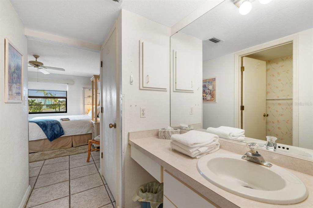 2275 South McCall Road, Unit 102 Englewood, FL 34224 - Photo 21 of 48 a en suite bathroom with a double vanity sink and a mirror