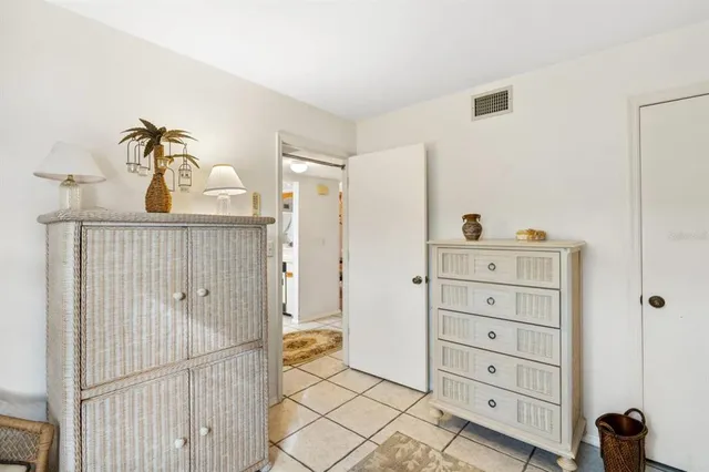 a bedroom with a dresser and a chandelier