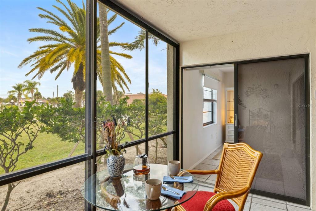 2275 South McCall Road, Unit 102 Englewood, FL 34224 - Photo 25 of 48 a view of a living room with a floor to ceiling window and wooden floor