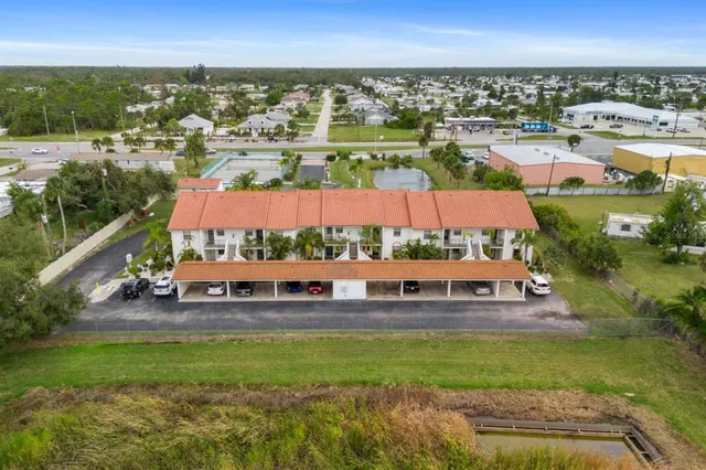 an aerial view of a house with a garden and lake view