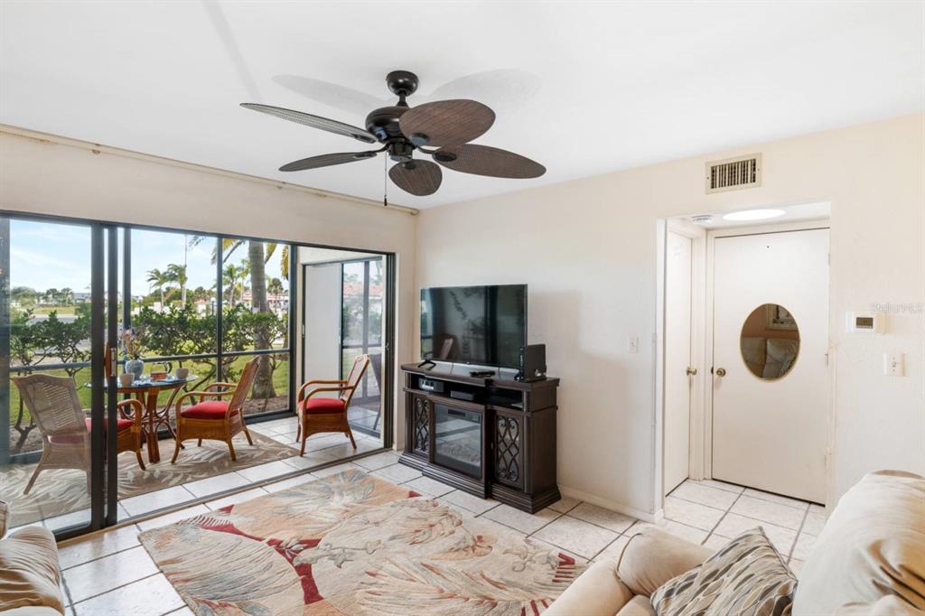 2275 South McCall Road, Unit 102 Englewood, FL 34224 - Photo 4 of 48 a living room with furniture and a flat screen tv