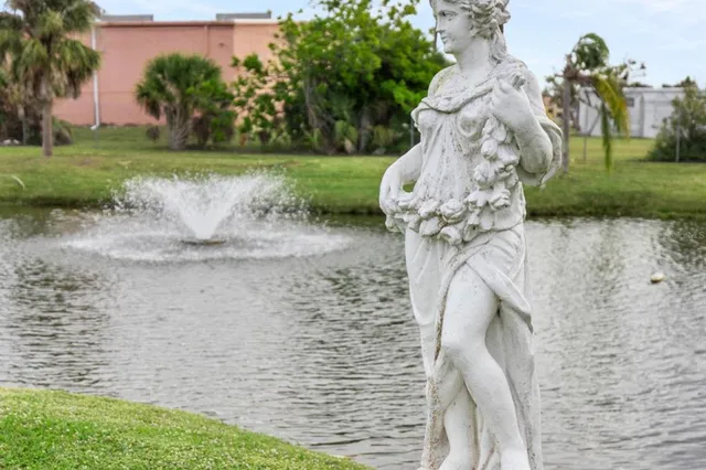 a view of a lake with a yard and large trees