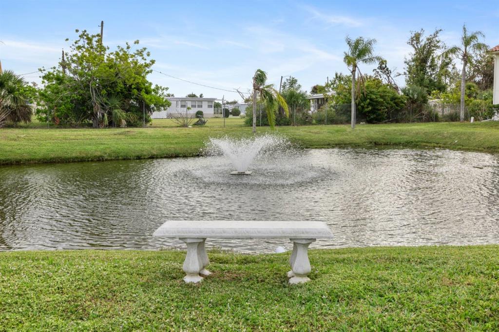 2275 South McCall Road, Unit 102 Englewood, FL 34224 - Photo 47 of 48 a view of a lake with a yard and large trees