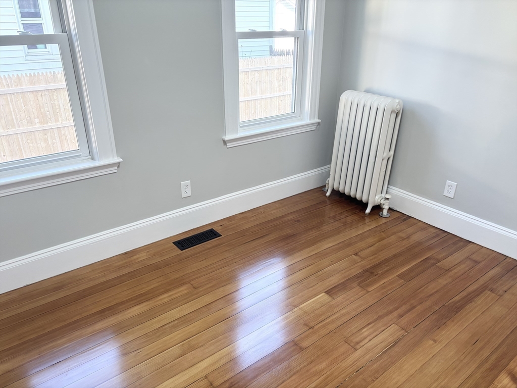 73 Dent Street, Unit 1 Boston, MA 02132 - Photo 14 of 36 a view of an empty room with wooden floor and a window
