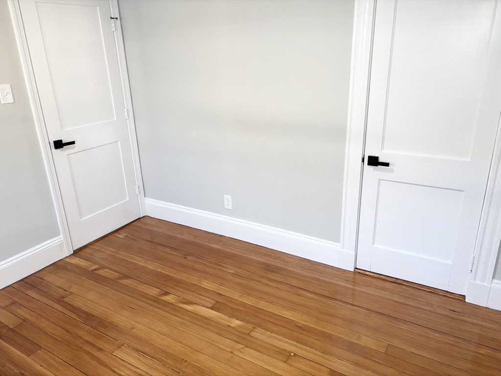 73 Dent Street, Unit 1 Boston, MA 02132 - Photo 15 of 36 an empty room with wooden floor