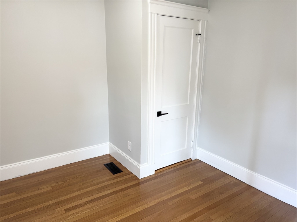 73 Dent Street, Unit 1 Boston, MA 02132 - Photo 23 of 36 a view of an empty room with wooden floor