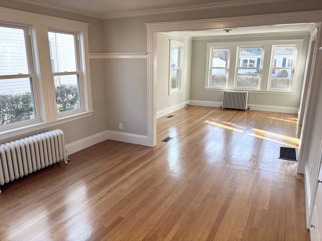 73 Dent Street, Unit 1 Boston, MA 02132 - Photo 5 of 36 a view of an empty room with wooden floor and a window