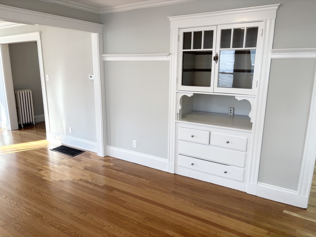 73 Dent Street, Unit 1 Boston, MA 02132 - Photo 8 of 36 a view of an empty room with wooden floor and cabinet