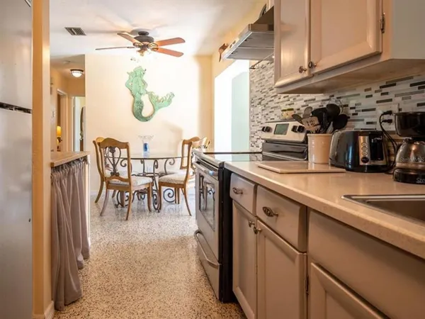 a kitchen with stainless steel appliances granite countertop a sink a stove and a refrigerator