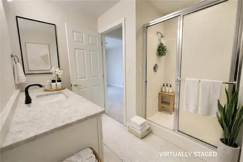 a bathroom with a granite countertop sink a mirror and shower