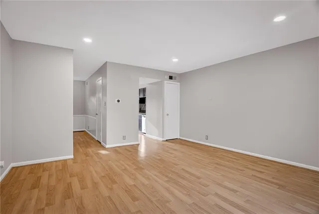 a view of an empty room with wooden floor
