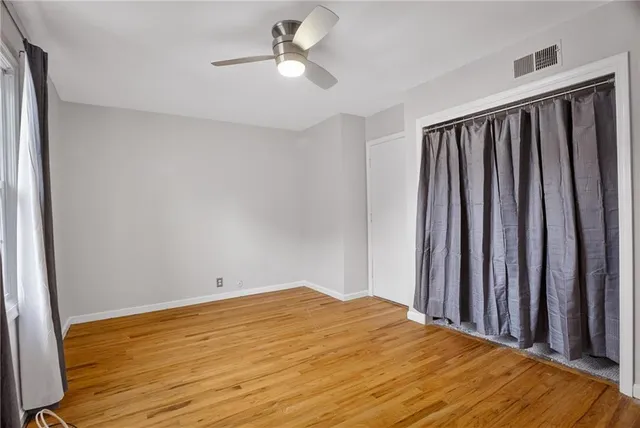 a view of a livingroom with wooden floor and a ceiling fan