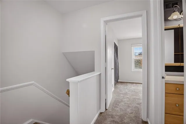 a view of hallway with sink and wooden floor