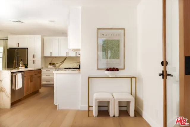 a kitchen with white cabinets and stainless steel appliances
