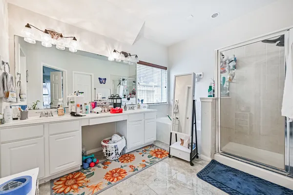 a bathroom with a sink mirror and shower