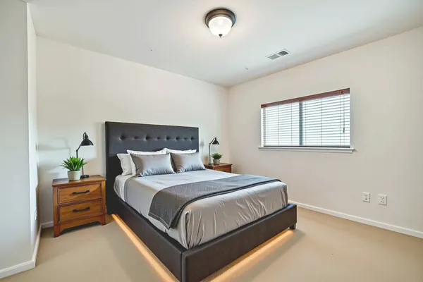 a bedroom with a bed and a night stand