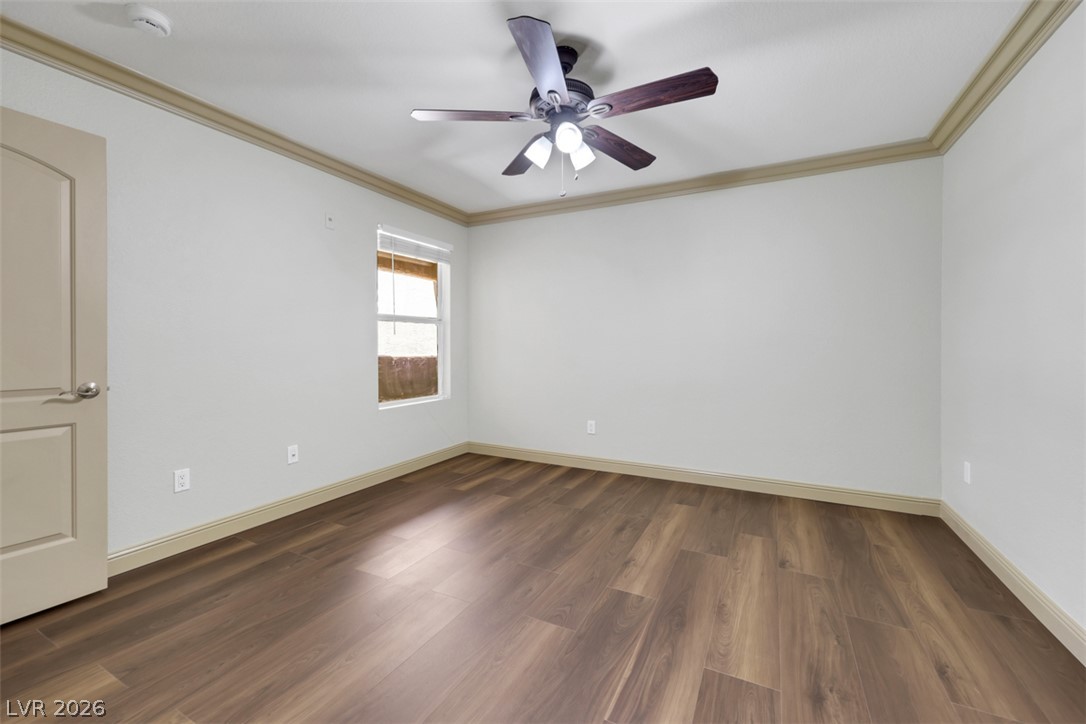 8101 West Flamingo Road, Unit 2136 Las Vegas, NV 89147 - Photo 28 of 32 Rich wood-inspired floors and classic crown molding define this versatile bedroom.