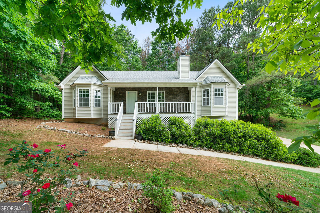 a front view of a house with a yard and potted plants