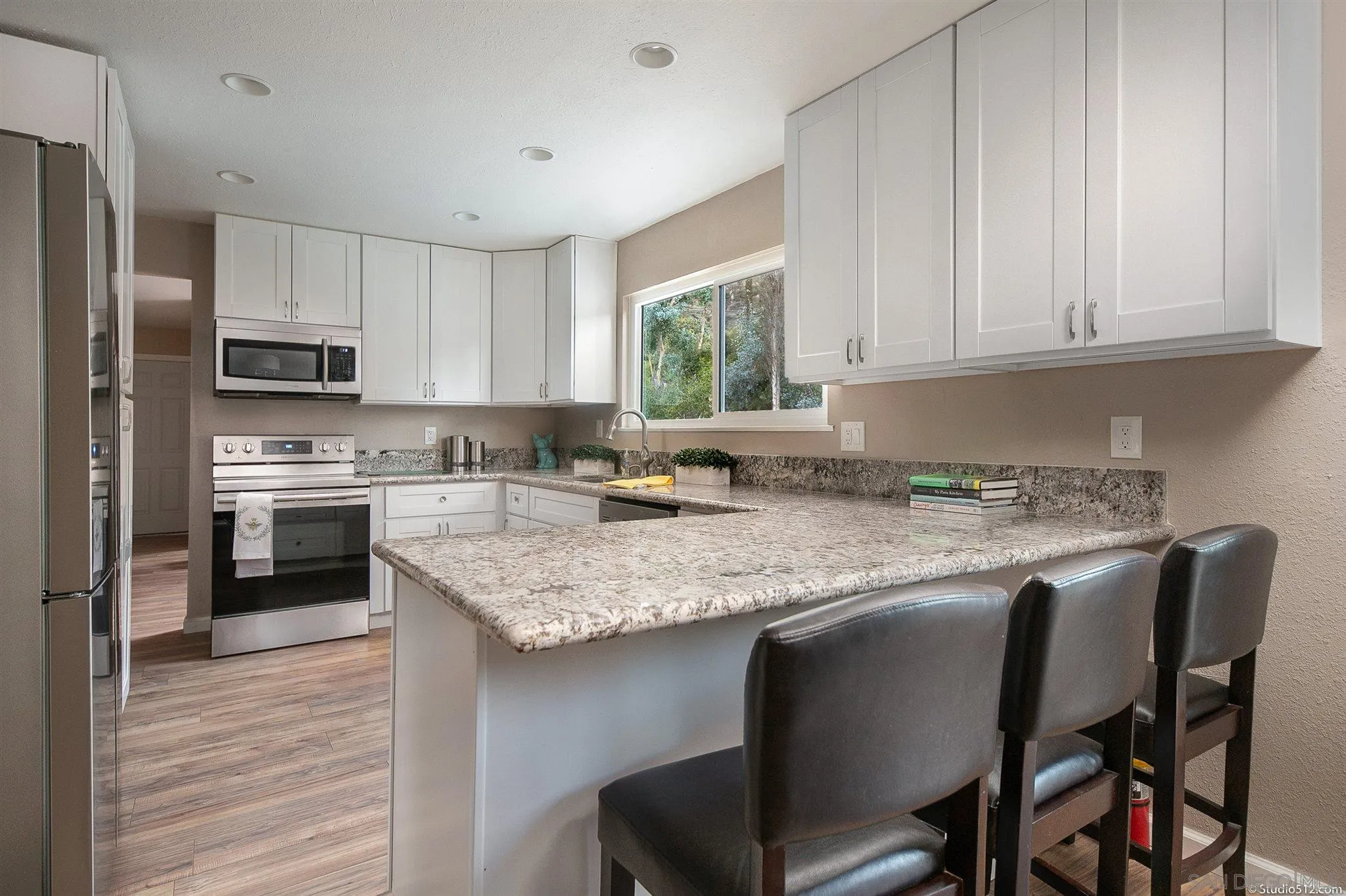 11425 Betsworth Road Valley Center, CA 92082 - Photo 9 of 24 a kitchen with stainless steel appliances granite countertop a table chairs sink refrigerator and cabinets