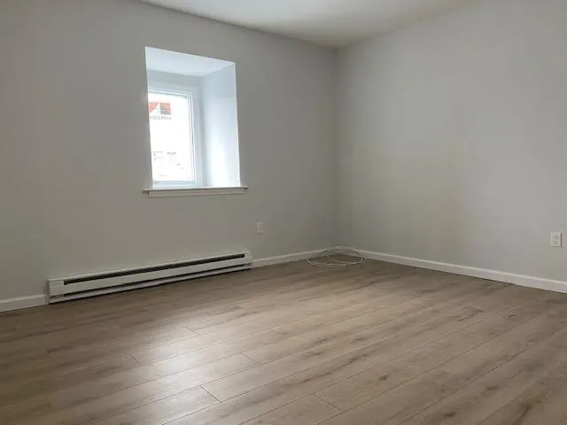 a view of a room with wooden floor and window