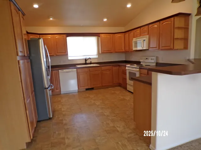 a kitchen with stainless steel appliances granite countertop a refrigerator and a sink
