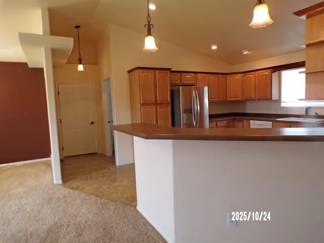a kitchen with stainless steel appliances granite countertop a refrigerator and a sink