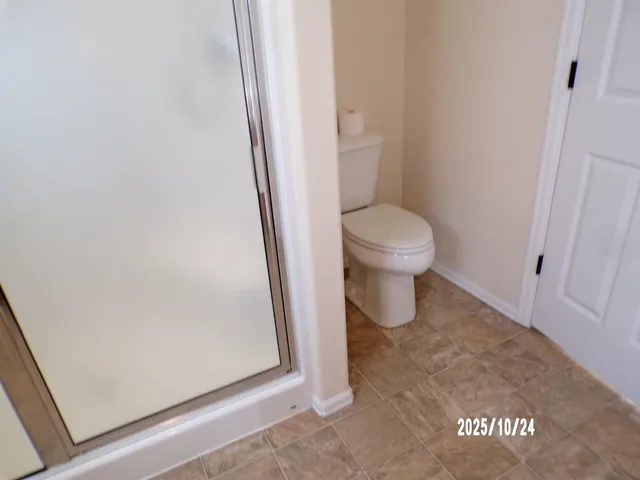 a bathroom with a toilet and a shower