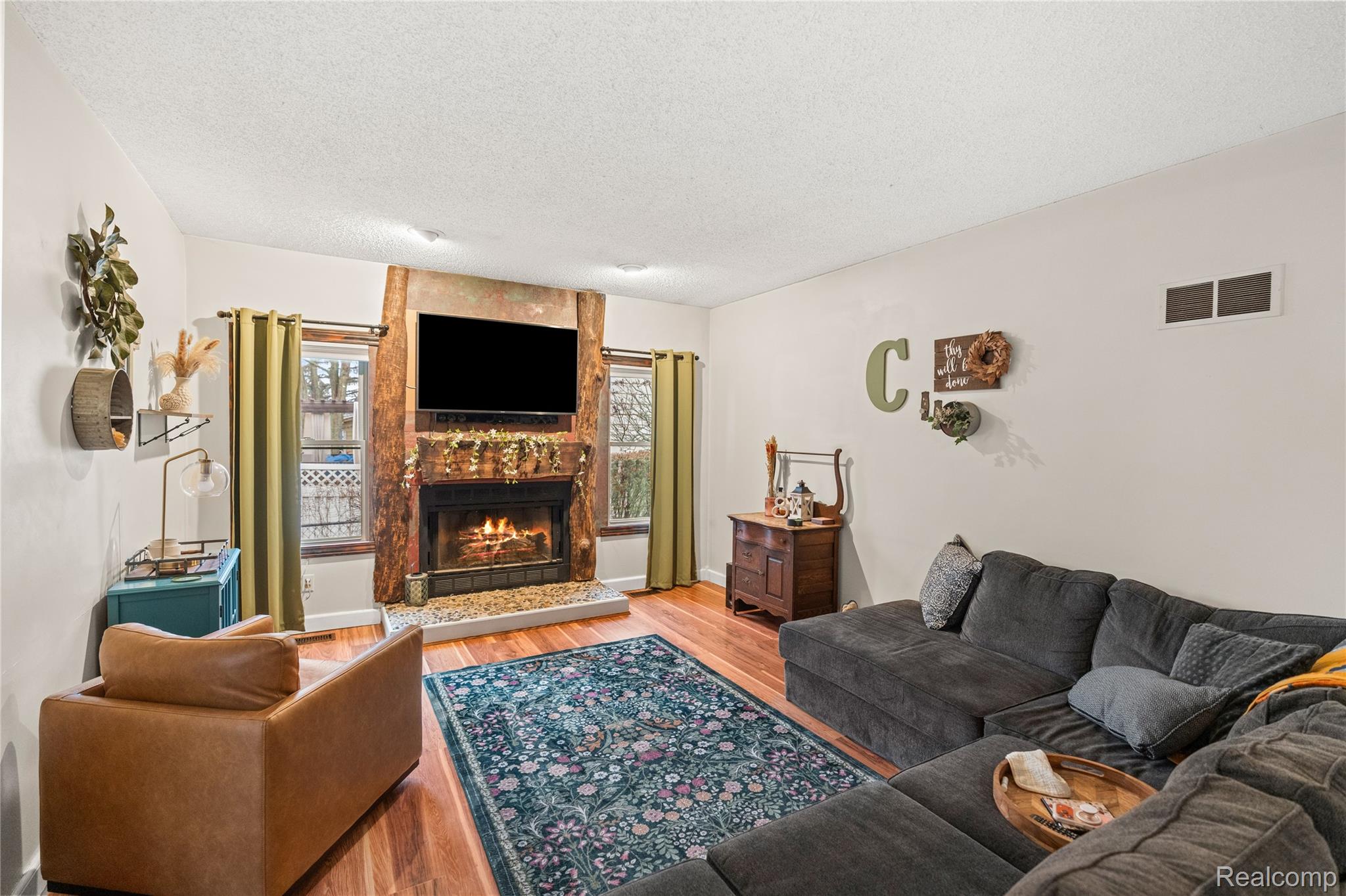 6076 East Carpenter Road Flint, MI 48506 - Photo 13 of 67 Living area with a fireplace, light wood-style flooring, and a textured ceiling