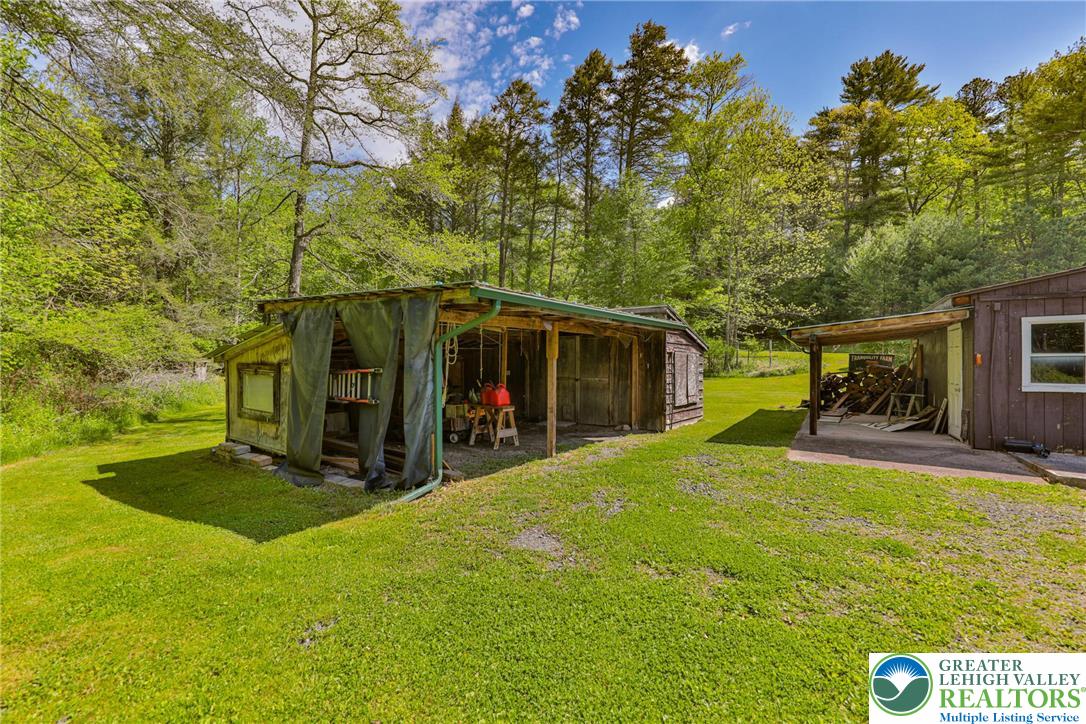 331 Cranberry Creek Road Cresco, PA 18326 - Photo 70 of 95 A secluded wooded setting featuring two rustic sheds and a vast, verdant lawn.