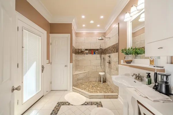 a spacious bathroom with a double vanity sink a mirror and shower